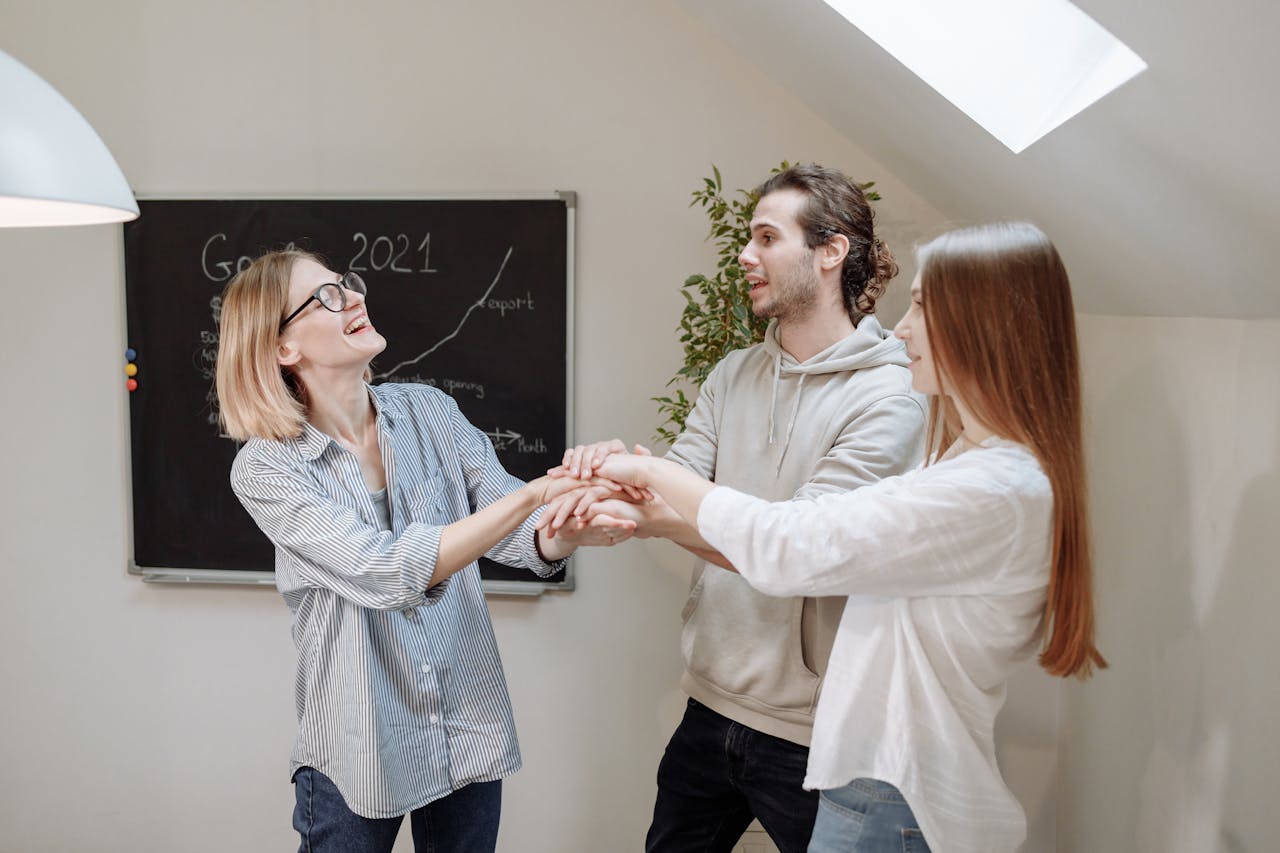 Young coworkers celebrate success with joy and teamwork indoors.